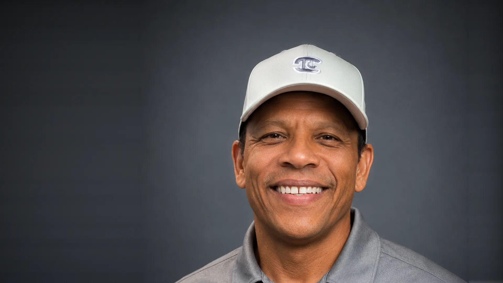 The owner of All Phase Contractors, smiling, in his work cap and company polo