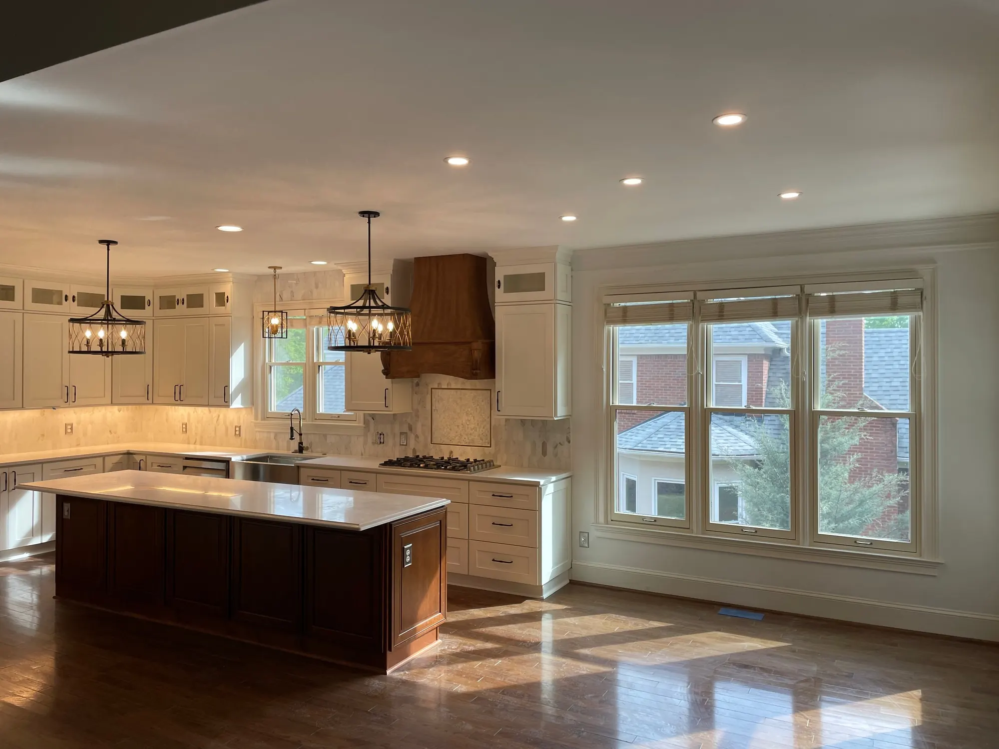 Finished kitchen with a walnut island, copper range hood and pendant lights