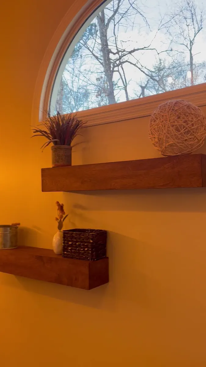 Floating shelves beneath an arched window
