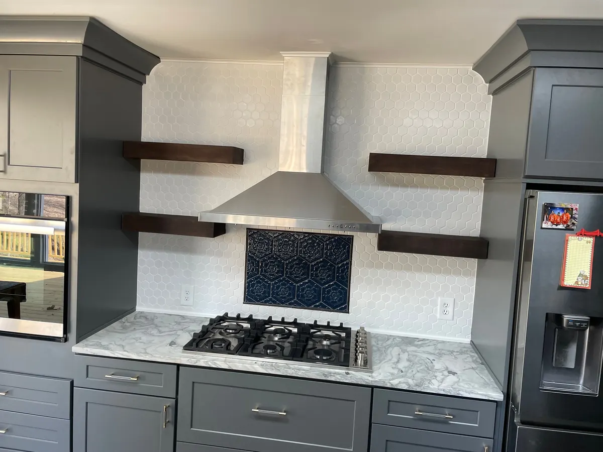 Grey shaker kitchen with a white range hood and subway tile